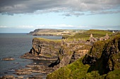 View of Dunluce Castle on cliffs and Atlantic Ocean in Ireland, UK