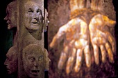 Close-up of face sculptures on pole at Saint Patrick Centre, Ireland, UK