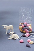 Lamb figurines with colourful sugar eggs on grey background