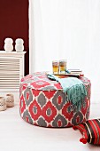 A pouffe and books, floor cushions and tea lights on the floor