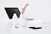 Laptop, vases, mouse pad and pen on white background