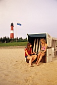 Two woman sitting in beach chair at Sylt, Germany