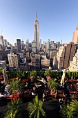 View of cityscape overlooking people sitting on rooftop bar at New York, USA