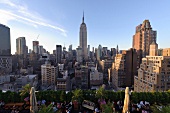 View of cityscape overlooking people sitting on rooftop bar at New York, USA