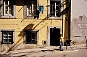 Girl playing on street of Alfama, Lisbon, Portugal