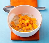 Sesame porridge with mango pieces in bowl for lactation