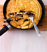 Pancake cut with fork in frying pan, step 2