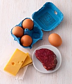 Eggs, cheese and beef on wooden surface - food rich in zinc