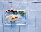 Lemon with sea salt, cinnamon and bay leaf on glass plate