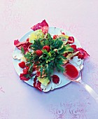 A mixed leaf salad with fresh raspberries and raspberry oil