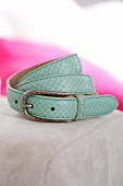 Close-up of mint coloured belt in python leather