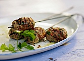 Close-up of grilled minced meat skewer on tray in summer kitchen