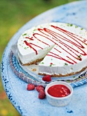 Lime cheesecake with berry sauce on table in summer kitchen