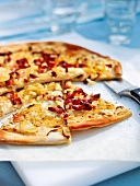 Pizza with bacon and onions on baking paper