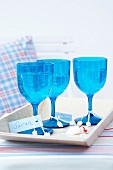 Three blue glasses with name tag on tray