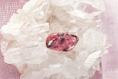 Heilen mit Edelsteinen - Ein Rhodonit liegt auf Bergkristallen