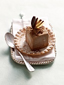 Praline truffle on shortcrust tartlets with icing sugar on plate