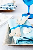 Tourquiose coloured napkins with wooden cutlery and seashells