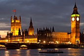 View of illuminated Palace of Westminster, Big Ben and river Thames, London, UK