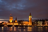 View of illuminated Palace of Westminster, Big Ben and river Thames, London, UK