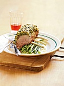 Rack of lamb with coating of herbs and olive mixture on plate, France