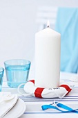 White candle on life preserver shaped candle holder