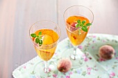 Peach punch with basil leaves in glasses