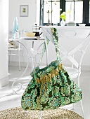 Green shoulder bag hanging on chair