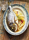 Sea bream with vegetables in serving dish, France