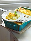 Mashed potatoes and fish casserole on plate and in baking dish, France