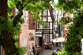 View of people on Schnoor street in Viertel through window, Bremen, Germany