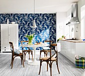 Moderne weiße Landhausküche mit blau- weiß tapezierter Wand