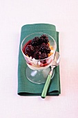 Blackberry compote with meringue in glass bowl
