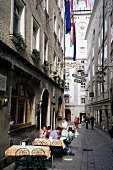 People sitting in outdoors cafe in an alley of old town, Salzburg, Austria