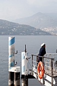 Sailor standing on boat dock and looking at Lake Como in Como, Lombardy, Italy