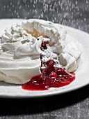 Close-up of meringue with icing sugar and berry filling