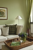 Creme sofa with patterned cushions and wicker basket with flower vase in living room