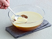 Removing grease by spoon from cold broth in bowl, method 1