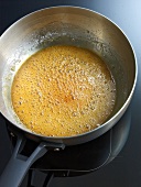 Boiled sugar and water in pan for preparation of caramel, step 3