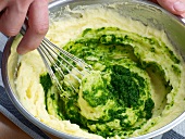 Adding herb puree in mixture for colour while preparing sauce