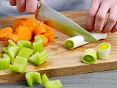 Hand cutting vegetables for preparation of chicken broth, step 2
