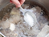 Close-up of sugar being added in mixture for preparation of beef stock, step 3