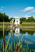 View of Schleswig Gottorp Castle Park with statue reflection in water, Baltic Coast