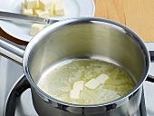 Butter being melted in pan for preparation of white roux, step 1