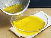 Pouring clarified butter in glass dish, step 3
