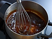 Whisking stock of demi glace veal in pan, step 7