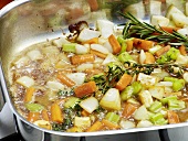 Close-up of vegetables being boiled in pan for preparation of bratenjus, step 3