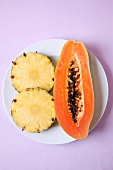 Pineapple slices and papaya on plate for Enzyme therapy