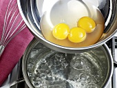Egg yolks being added in boiling water for preparation of hollandaise sauce, step 3