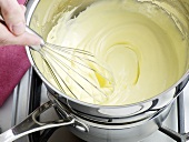 Mixture being whisked for preparation of hollandaise sauce, step 4